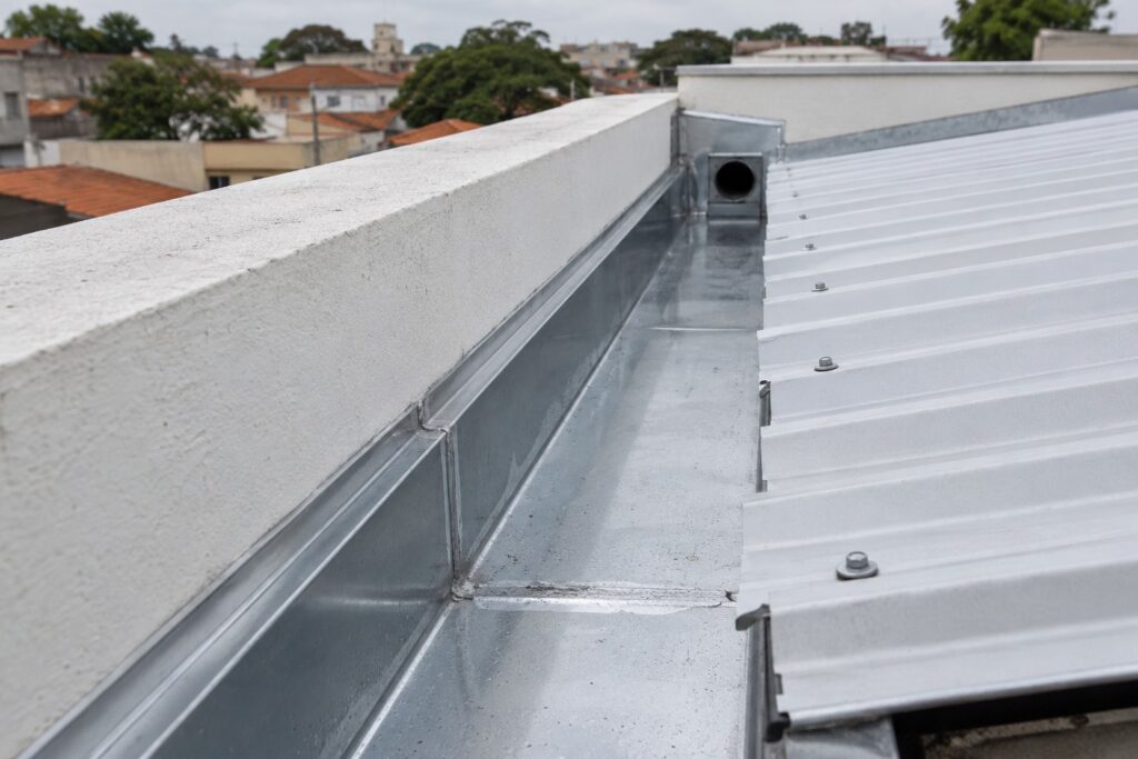 Calha metálica sob medida instalada entre o telhado e a platibanda